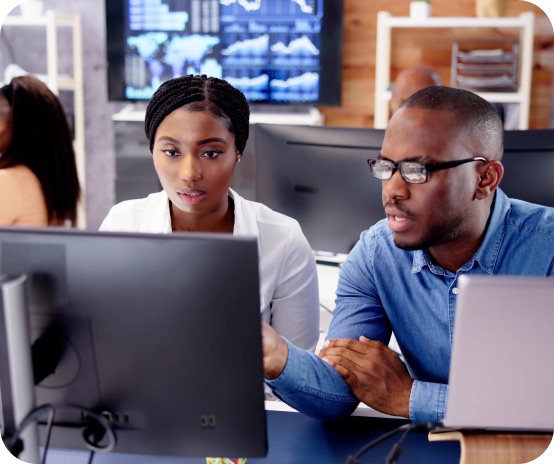 A man and a woman working in front of a computer